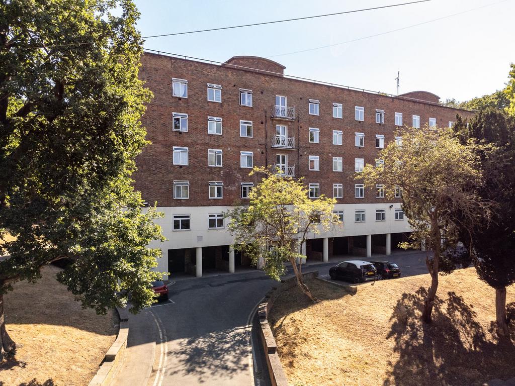 Dunton Court’s brick exterior, with trees, lawns, and a curved driveway in front.